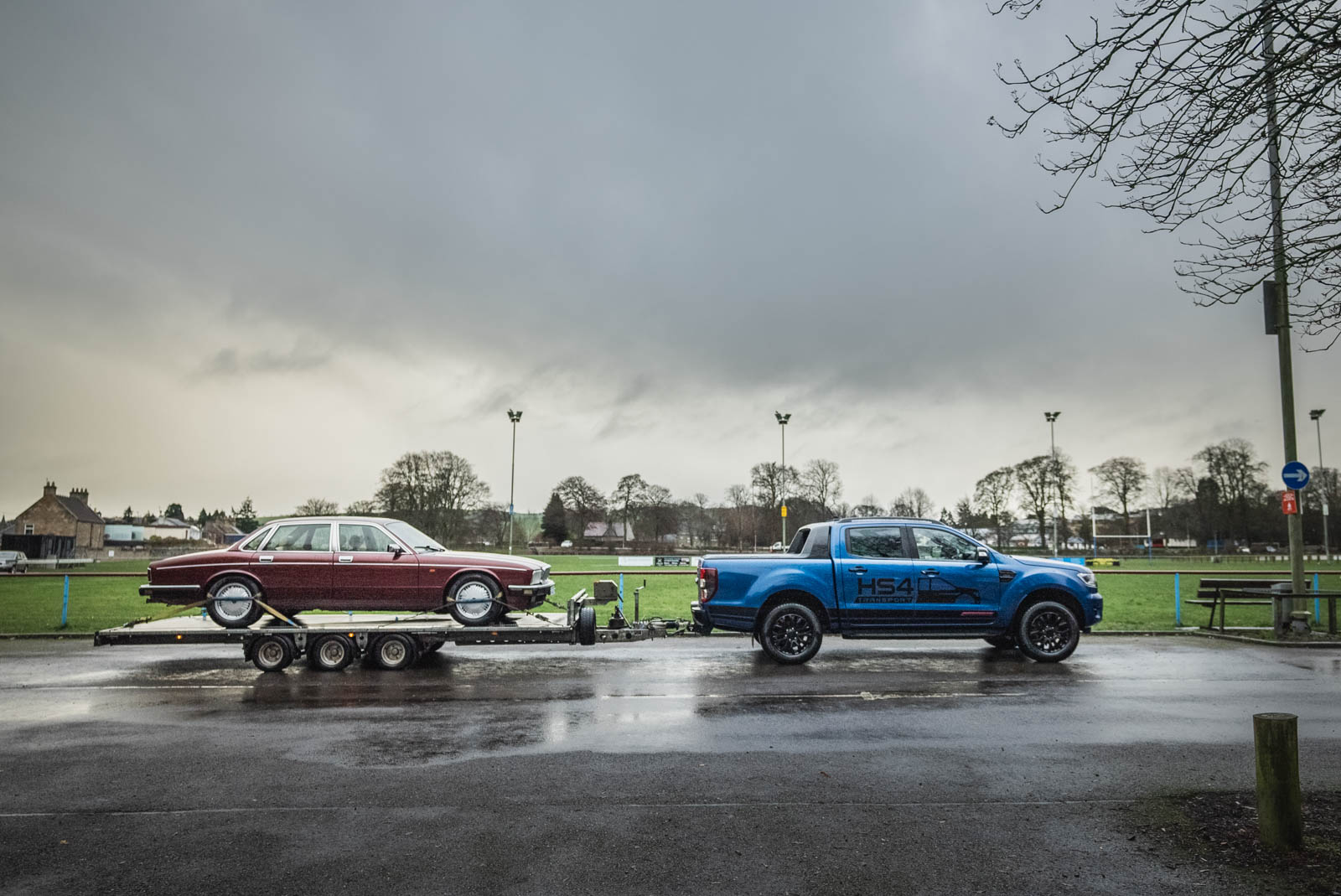 HS4 Transport blue Ford Ranger towing a flatbed trailer with a classic car
